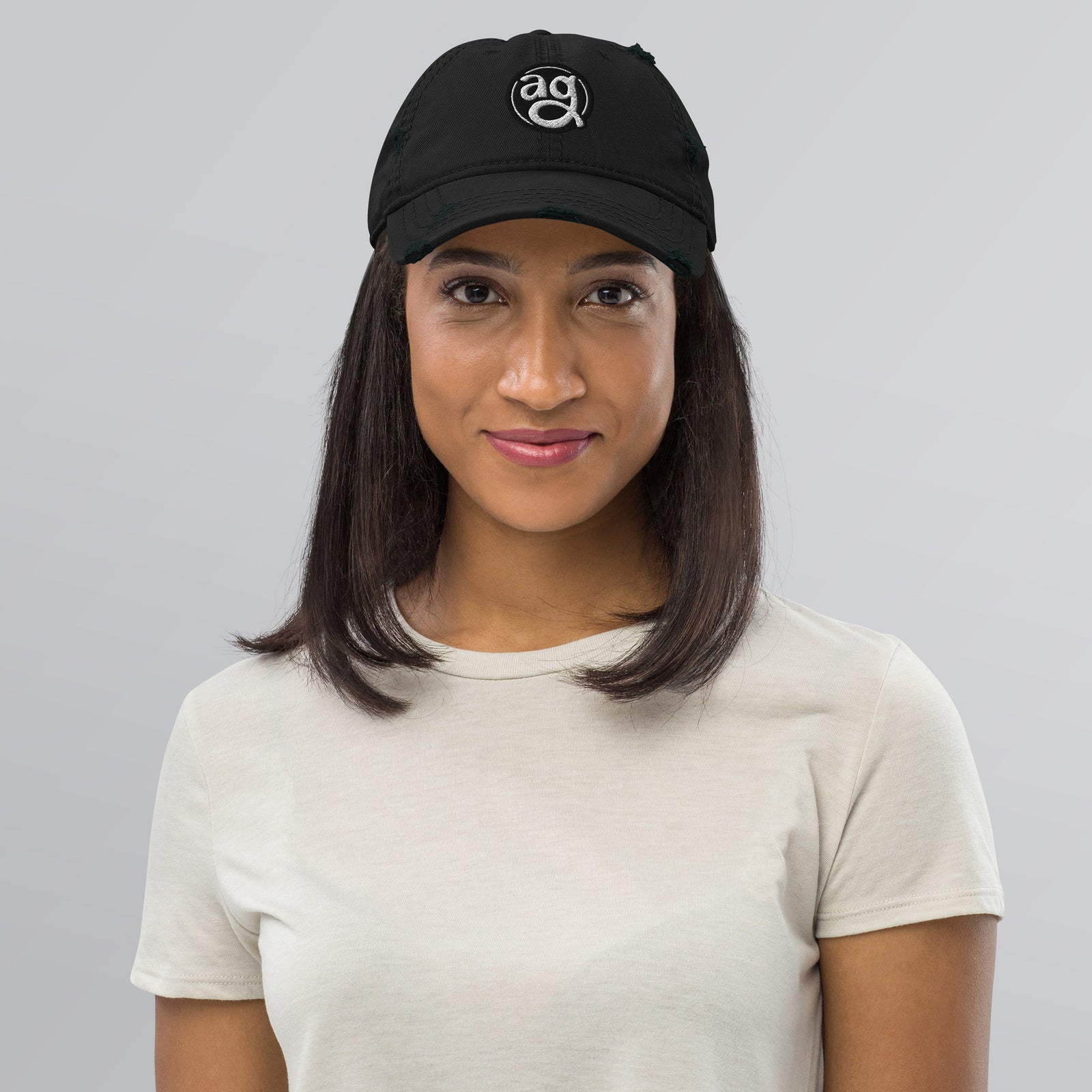 AG - Woman wearing a black cap with a logo on a gray background