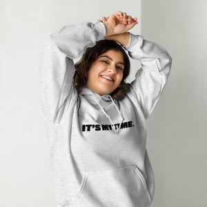 AG - Woman wearing a ash hoodie with 'IT'S MY TIME' text, smiling against a plain background