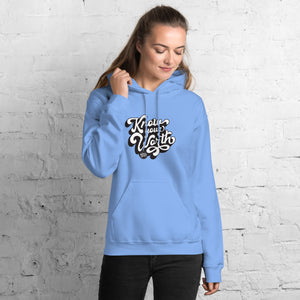AG - Woman wearing a carolina blue hoodie with, know your worth, text against a white brick wall.
