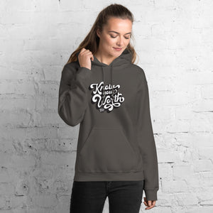 AG - Woman wearing a charcoal hoodie with, know your worth, text against a white brick wall.
