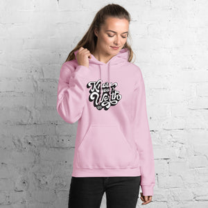 AG - Woman wearing a light pink hoodie with, know your worth, text against a white brick wall.
