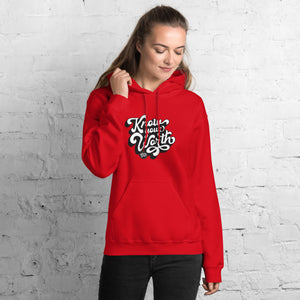 AG - Woman wearing a red hoodie with, know your worth, text against a white brick wall.
