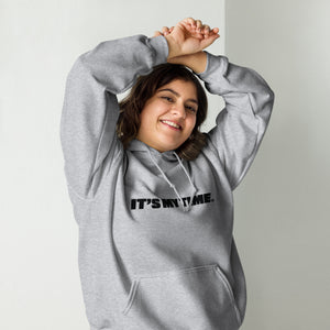 AG - Woman wearing a gray hoodie with 'IT'S MY TIME' text, smiling against a plain background