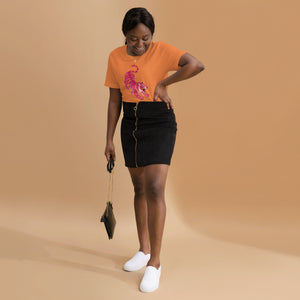 AG - Woman wearing a burnt orange t-shirt, with a tiger graphic design, on a beige background